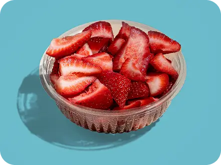 Freshly sliced strawberries in a bowl, vibrant and ready to complement your poke bowl experience at Times Square.