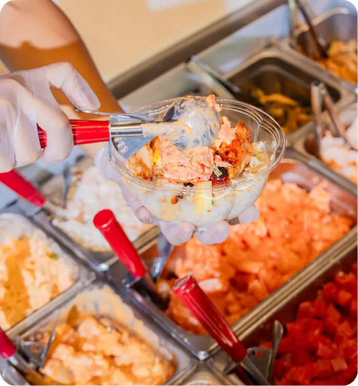 Hell's Kitchen poke bowl preparation with fresh ingredients and vibrant sauces.