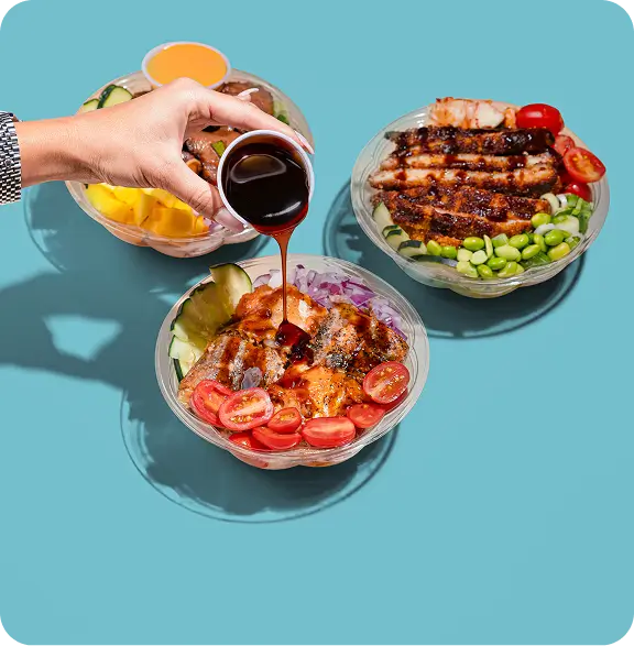 Customizable poke bowls with fresh ingredients being drizzled with sauce, Long Island City restaurant special.